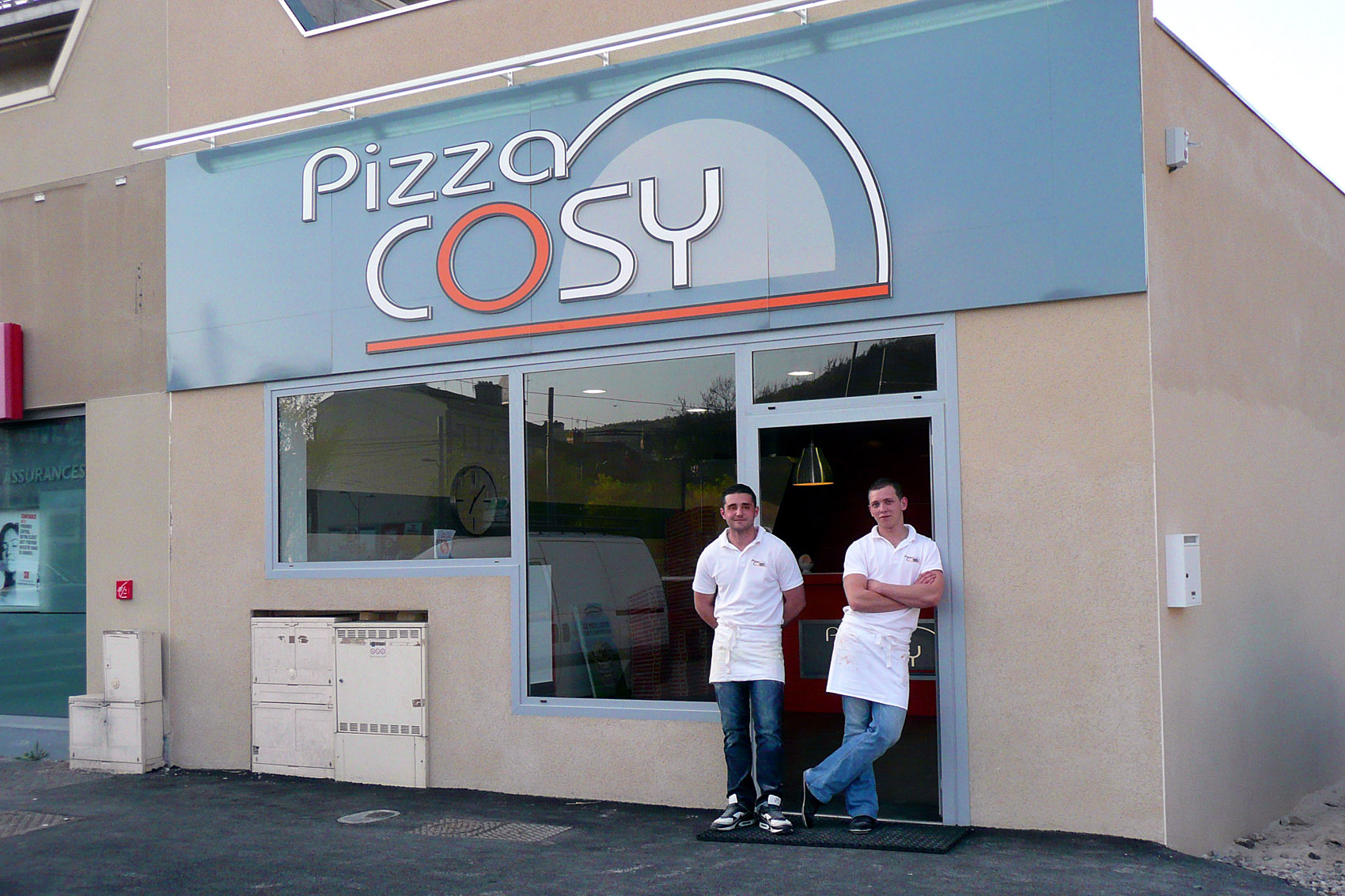 Photo du premier pizza cosy avec les deux associés devant la porte.